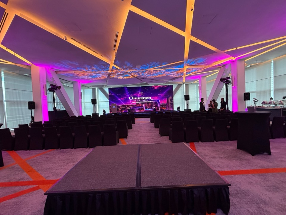 Launch event room with an LED wall, a stage platform and rows of chairs under a coloured ceiling