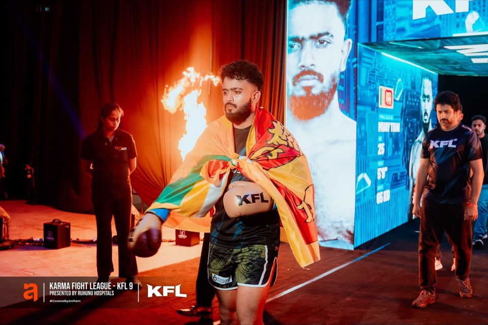 Fighter walking out with a flag past a giant LED screen