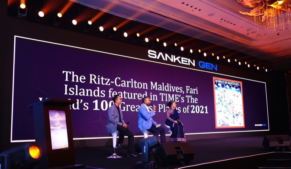 Panel discussion on stage in front of a large LED wall