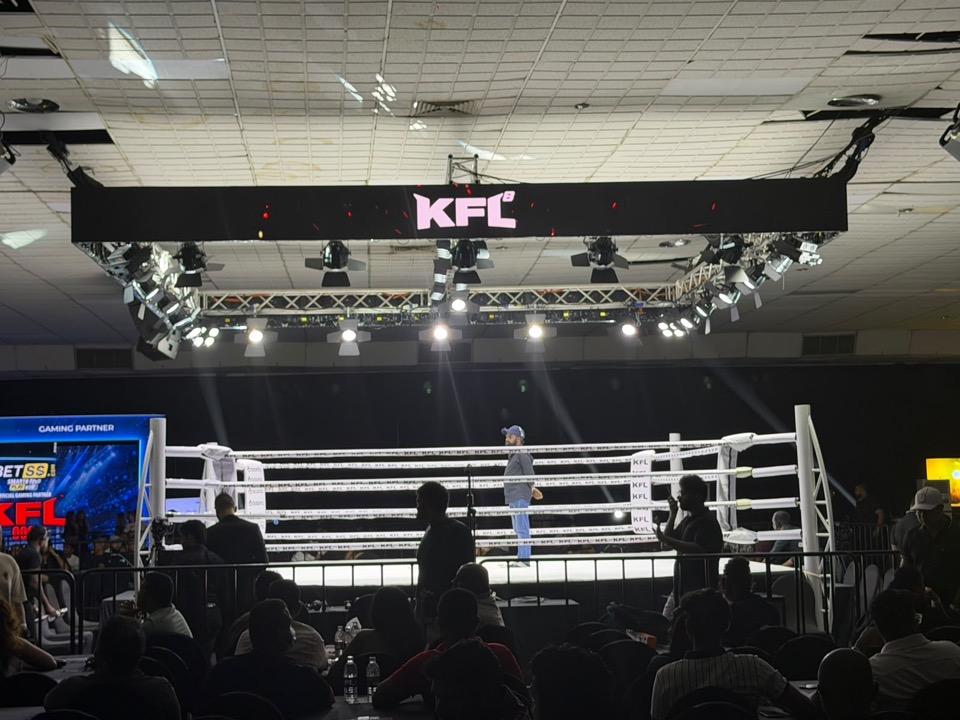 Boxing ring with a hanging LED sign and lighting rig