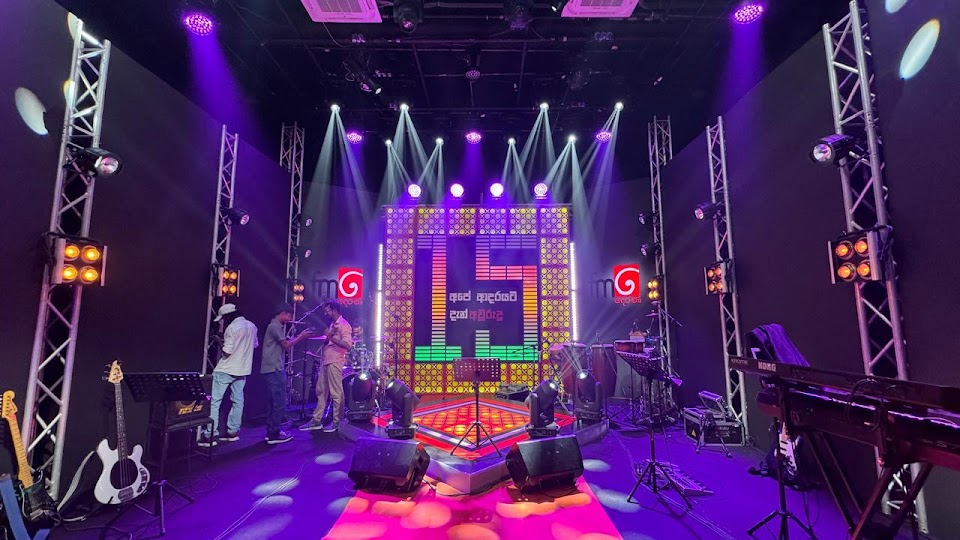 Stage set with truss towers and an illuminated backdrop