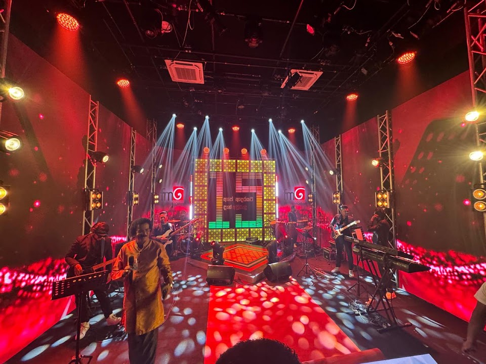Band performing on a lit stage with LED walls