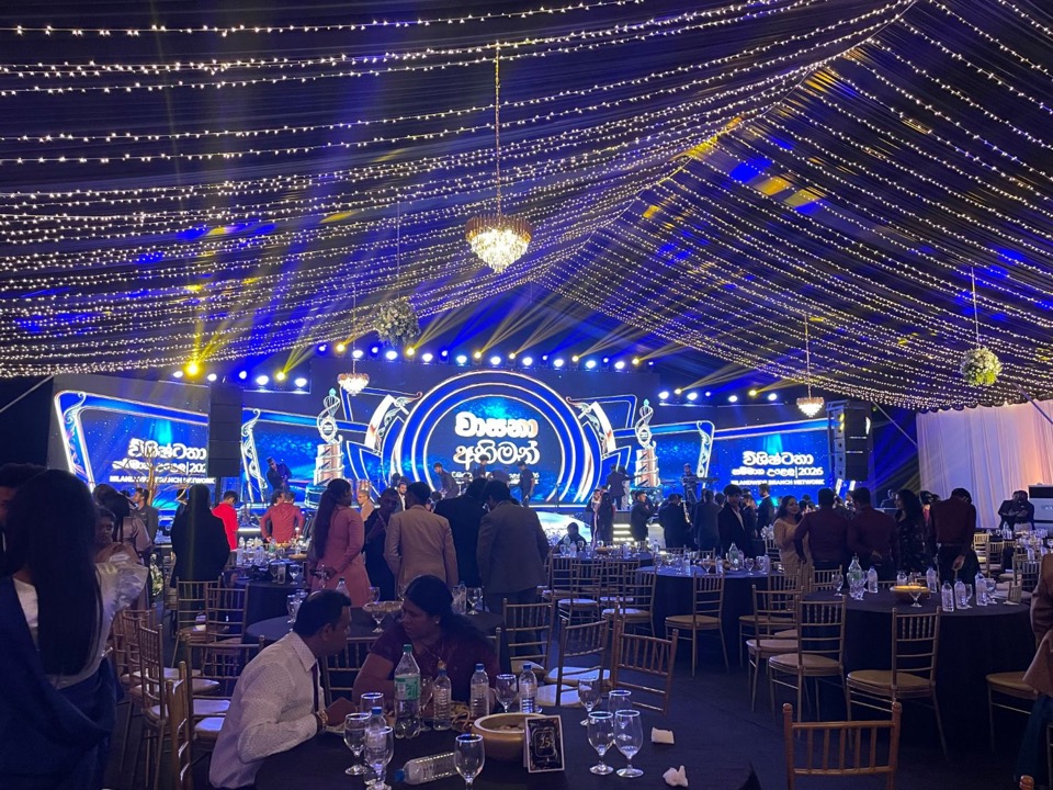 Awards night in a tent with blue beams and fairy lights
